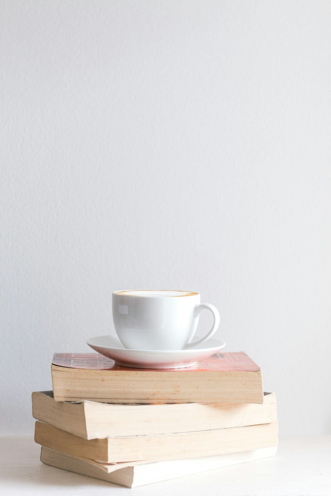 Stack of hardcover mystery books with a cup of coffee